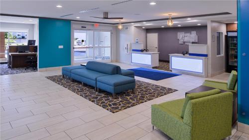 a lobby with a couch and two chairs and a kitchen at Holiday Inn Express & Suites Lexington Midtown - I-75 by IHG in Lexington