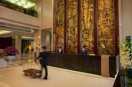 a man walking through a lobby of a building at Holiday Inn Foshan Nanhai Central by IHG in Foshan