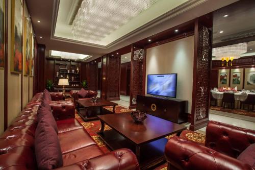 a lobby with leather furniture and a flat screen tv at Holiday Inn Foshan Nanhai Central by IHG in Foshan