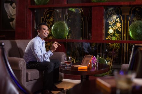 a man sitting in a chair in a room at Holiday Inn Foshan Nanhai Central by IHG in Foshan