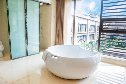 a large white bath tub in a bathroom with a window at Holiday Inn Foshan Nanhai Central by IHG in Foshan