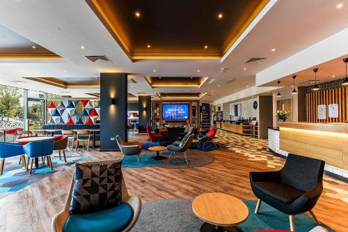 a lobby of a hotel with chairs and tables at Holiday Inn Express - Bicester by IHG in Bicester