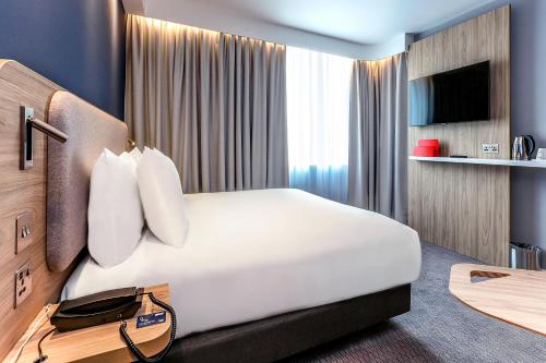 a hotel room with a large bed and a tv at Holiday Inn Express - Bicester by IHG in Bicester