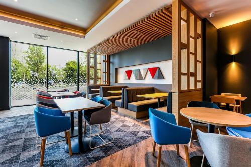a restaurant with tables and chairs and a waiting room at Holiday Inn Express - Bicester by IHG in Bicester