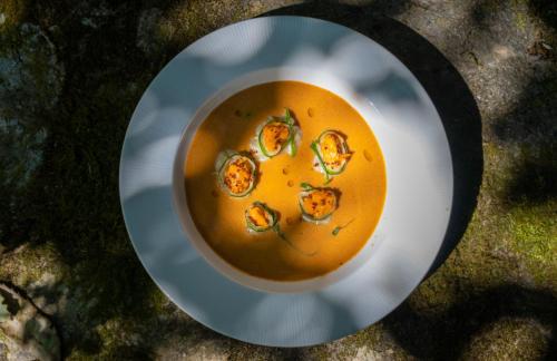 a bowl of soup on a plate on the grass at Mary Budden Estate in Almora