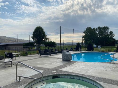 a swimming pool with chairs and a table at Holiday Inn Clarkston - Lewiston by IHG in Clarkston