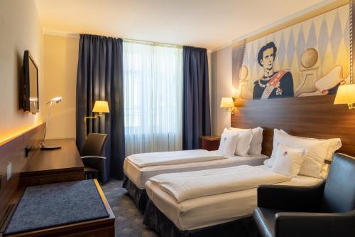 ein Hotelzimmer mit 2 Betten und einem Stuhl in der Unterkunft Hotel König Ludwig II in Garching bei München