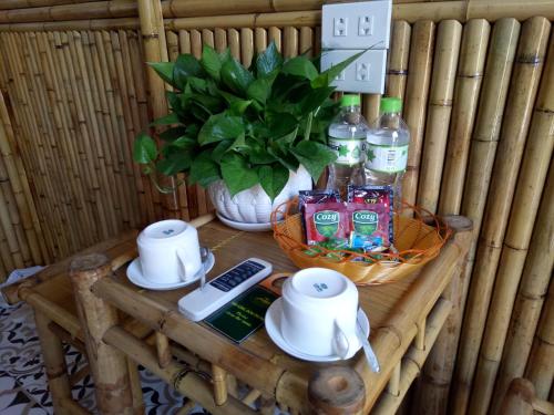 a table with a remote control and a vase with a plant at Tam Coc Village Bungalow in Ninh Binh