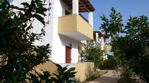 a white building with a balcony on the side of it at Socrates Studios & Apartments in Acharavi