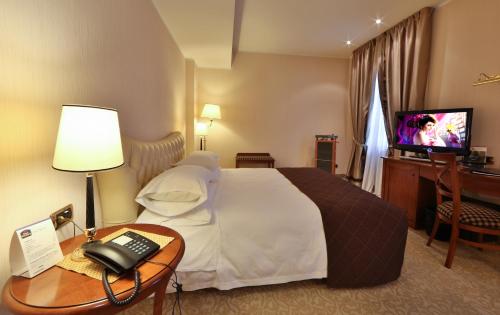 a hotel room with a bed and a television at Hotel Master in Brescia