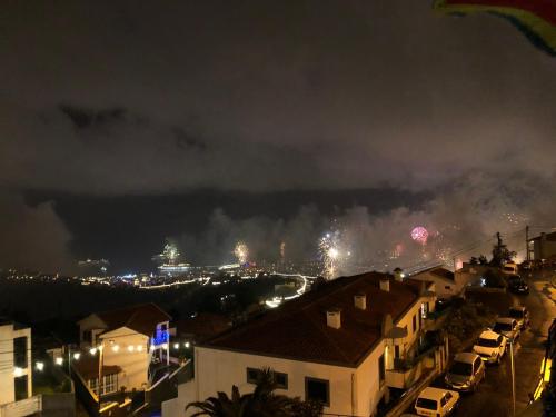 a view of a city at night with smoke at Casa Alegria in Funchal