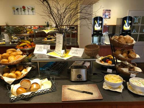 a buffet with bread and other foods on a counter at AVALON Hotelpark Königshof in Königslutter am Elm