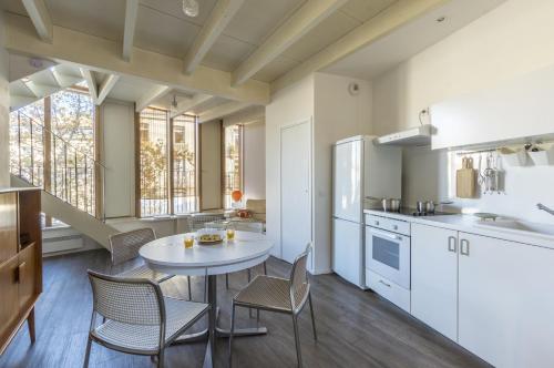 une cuisine avec une table et des chaises dans une pièce dans l'établissement Duplex En Aparté - Première conciergerie, à Montpellier