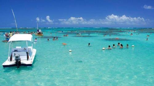 een groep mensen in het water op een strand bij Pousada Catamarã Anexo in Maceió