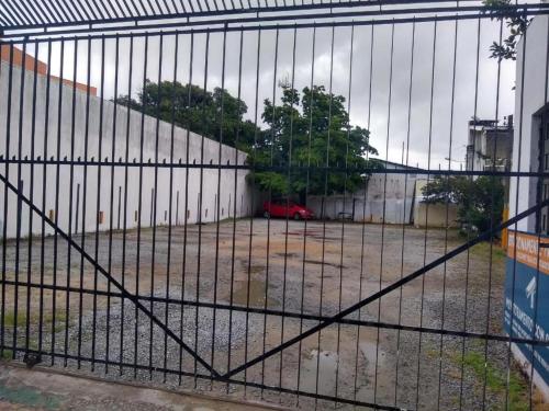 a fence with a car parked in a parking lot at Pousada Catamarã Anexo in Maceió