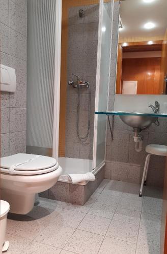 uma casa de banho com um chuveiro, um WC e um lavatório. em Hotel das Taipas em Guimarães