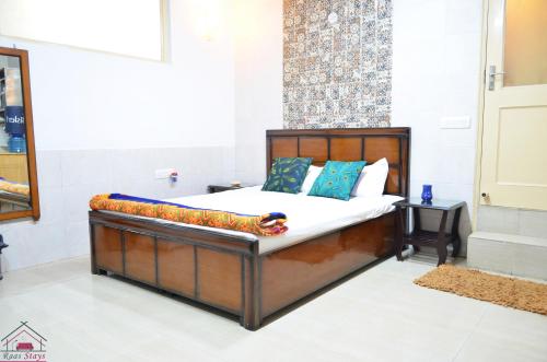 a bed with a wooden frame with a pillow on it at Furnished 1 Bedroom Independent Apartment 1 in Greater Kailash 1 Delhi in New Delhi