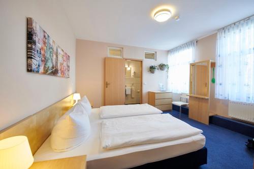 ein Hotelzimmer mit 2 Betten und einem Bad in der Unterkunft Hotel Zum Grunewald in Dinslaken