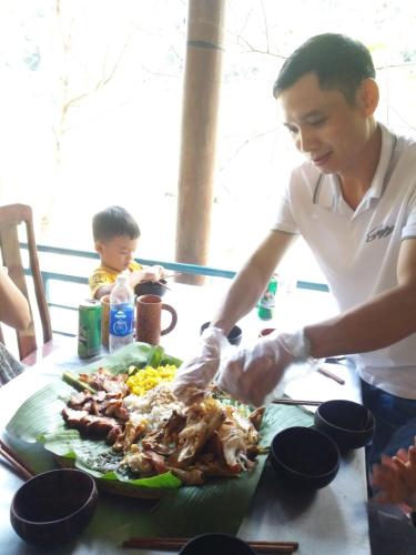 a man preparing a plate of food on a table at Vagibi Hotel in Dong Hoi