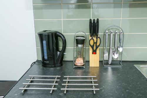 a kitchen counter with utensils on a counter top at Wilmington Lodge Dartford London in Kent