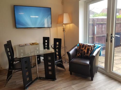 uma sala de estar com uma mesa e cadeiras e uma televisão em Ladysmith House - 4 Bedrooms - Full House em Grimsby