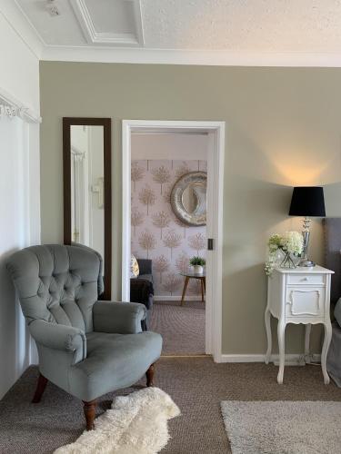 a living room with a chair and a mirror at Thorn House in Fen Drayton