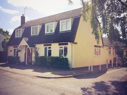 a white house with a black roof at Thorn House in Fen Drayton