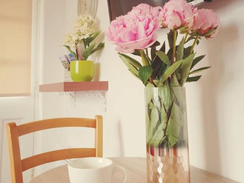 a vase with pink flowers sitting on a table at Thorn House in Fen Drayton