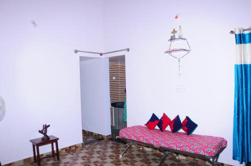 a room with a bench with red and black pillows at The Pinto Cottage in Hassan