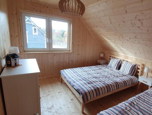 a bedroom with two beds in a wooden cabin at Ramlejowe Wzgórze - Sauna-Balia in Ostrzyce