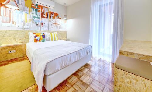 a bedroom with a bed and a large window at Hotel do Mercado in Aveiro