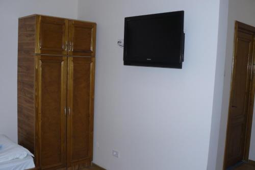 a bedroom with a tv and a wooden cabinet at Hotel Adial in Adjud