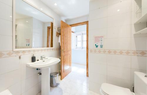 La salle de bains est pourvue d'un lavabo, de toilettes et d'un miroir. dans l'établissement El Tribunal de Barceló, à Madrid