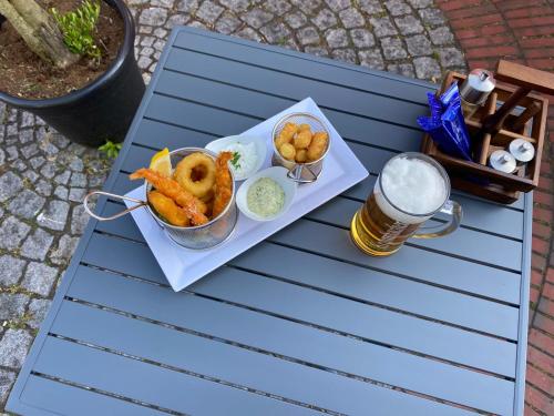 a plate of food with a bowl of onion rings andbeer at MediTerra in Papenburg