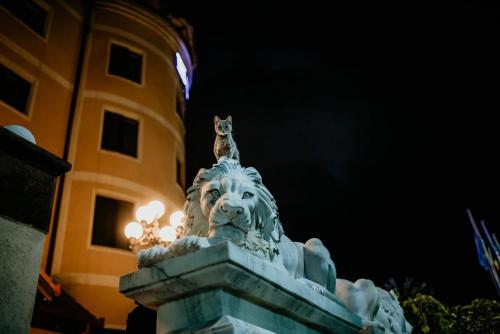 a statue of a lion with a cat on top of it at Hotel Coandi in Arad
