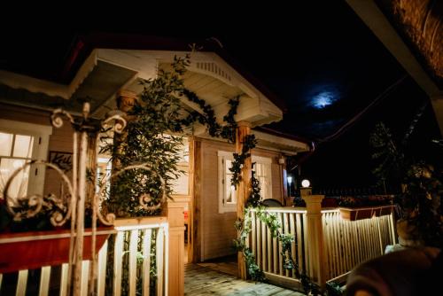 a house with a white fence in front of it at night at Hotel Coandi in Arad
