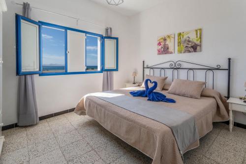 Un dormitorio con una cama con una cinta azul. en El Graciosero, en Caleta de Sebo