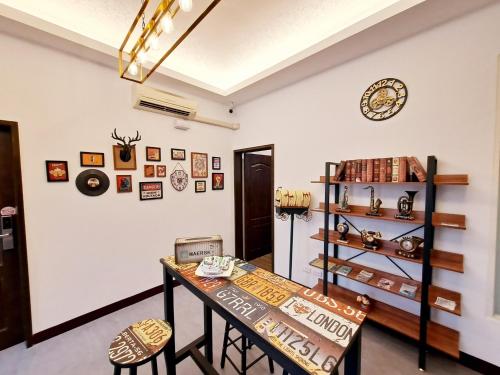 ein Zimmer mit einem Tisch und Stühlen sowie einer Uhr an der Wand in der Unterkunft You Yue B&B in Hualien