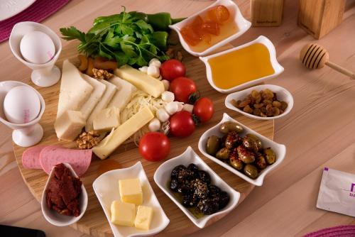 a table topped with different types of cheese and vegetables at Nun Hotel in Antalya