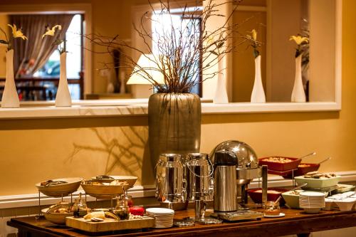 a table with dishes and a vase on top at Southern Sun Bloemfontein in Bloemfontein