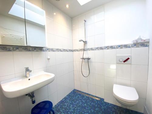 Baño blanco con lavabo y aseo en Vakantiehuis Domburg DO12, en Domburg
