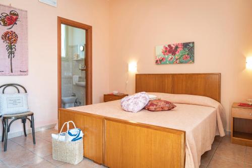 - une chambre avec un lit et une tête de lit en bois dans l'établissement Agriturismo Panacea, à Santa Cesarea Terme