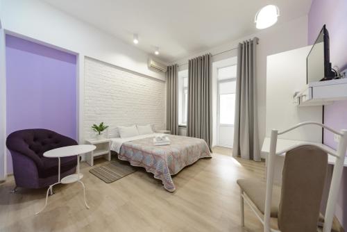 Zimmer mit einem Bett, einem Tisch und einem Stuhl in der Unterkunft Bessarabka Apartments in Kiew