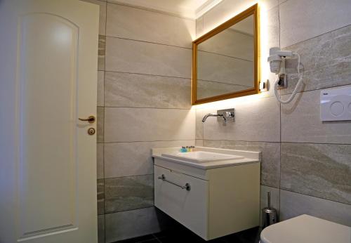 a bathroom with a sink and a mirror and a toilet at Kubaliç Hotel&SPA in Ordu
