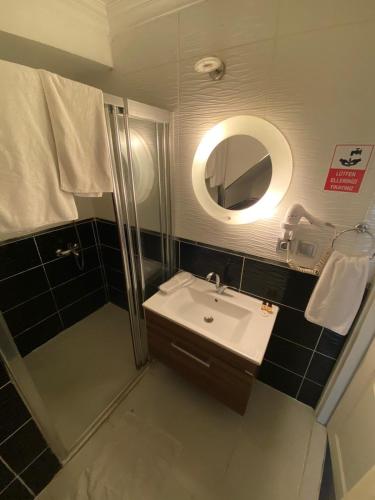 a bathroom with a sink and a shower with a mirror at Lena Central Flats in Bursa