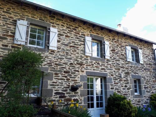 an old stone house with white shuttered windows at Le Venec, Lopérec, France in Lopérec