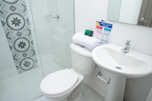 a bathroom with a toilet and a sink and a shower at Hotel Ayenda House Concepción 1317 in Barranquilla