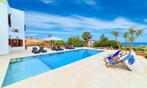 a villa with a swimming pool and a house at Cretan Dream Villa in Georgioupolis