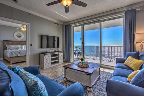 uma sala de estar com um sofá azul e uma televisão em Beachfront PCB Condo with Ocean Views and Pool Access! em Panama City Beach