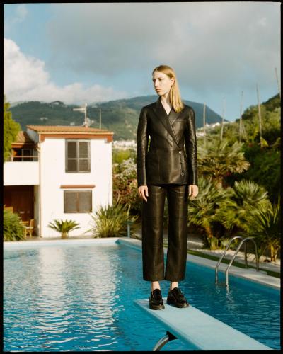 a woman standing on a surfboard next to a pool at Villa Aurora in Vico Equense